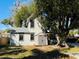 Backyard view of the house, shed, and wooden deck under a large shade tree at 428 E Orange Ave, Eustis, FL 32726