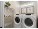 Functional laundry room with modern washer and dryer, overhead shelving, and a bright window at 6322 Dew Drop Loop, St Cloud, FL 34771