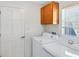 Laundry room with a washer, dryer, cabinet, a window, and white walls at 702 Barrington Cir, Winter Springs, FL 32708