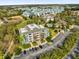 Aerial view of multi-story condo building with ample parking, surrounded by lush landscaping at 7613 Cabana Ct # 402, Reunion, FL 34747