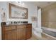 Bathroom featuring granite countertops, wood cabinets, and tiled shower at 7613 Cabana Ct # 402, Reunion, FL 34747