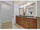 Bathroom with double sink, granite counters, and wood cabinets at 7613 Cabana Ct # 402, Reunion, FL 34747