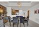 Open-concept dining room with modern light fixtures, with the kitchen partially visible in the background at 7613 Cabana Ct # 402, Reunion, FL 34747