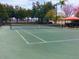 Green tennis court with net, fence, and covered seating area at 7613 Cabana Ct # 402, Reunion, FL 34747