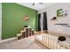 bedroom with green accent wall, wood flooring and a -sized basketball hoop at 7845 Dausset St, Orlando, FL 32827