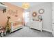 Charming Bedroom with peach accent wall, woven pendant light, and decorative wall mirrors at 7845 Dausset St, Orlando, FL 32827