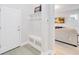 Mudroom entrance features built in bench and storage adjacent to the entryway and living room at 7845 Dausset St, Orlando, FL 32827