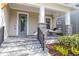 Inviting front porch with a cozy swing, stone pillars, and a decorative wreath on the blue front door at 7845 Dausset St, Orlando, FL 32827