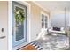 Inviting front porch with a cozy swing, stone pillars, and a decorative wreath on the blue front door at 7845 Dausset St, Orlando, FL 32827