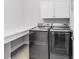 Laundry room featuring modern washer and dryer, white cabinets, and laminate countertops at 7845 Dausset St, Orlando, FL 32827