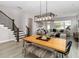 Open-concept living and dining area with hardwood floors and a staircase with rod iron railing at 7845 Dausset St, Orlando, FL 32827