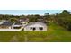 Grey home featuring a well-kept, spacious lawn bordered by a white fence and lush greenery at 820 E Flag Ln, Kissimmee, FL 34759