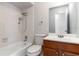 A clean bathroom is shown with a shower-tub combo and wooden vanity at 820 E Flag Ln, Kissimmee, FL 34759