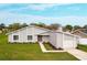 Charming single-story home with a well-manicured lawn and neutral gray paint at 820 E Flag Ln, Kissimmee, FL 34759