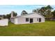 Back exterior of the home with a large lawn at 820 E Flag Ln, Kissimmee, FL 34759