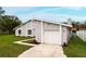 Attached garage with updated landscaping and freshly painted gray facade at 820 E Flag Ln, Kissimmee, FL 34759
