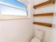 Renovated bathroom features floating shelves, white toilet, and a bright window at 820 Rayston, Deltona, FL 32725