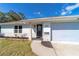 Inviting front entrance with brick accents, new landscaping, and a modern door with glass detail at 820 Rayston, Deltona, FL 32725