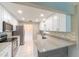 Open kitchen with white cabinets, stainless steel appliances and stone countertops at 820 Rayston, Deltona, FL 32725