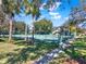 View of the community tennis courts with lush landscaping, trees, and secure fencing at 8314 Tangelo Tree Dr, Orlando, FL 32836