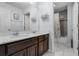 Bathroom featuring double sinks, dark wood cabinets, and a shower-tub combo at 9518 Lynwood St, Clermont, FL 34711