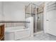 Bathroom showcasing a bathtub with a glass shower enclosure and white cabinets at 9518 Lynwood St, Clermont, FL 34711