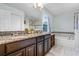 Well-appointed bathroom with double sinks, granite countertops, tile floors, and a soaking tub with a tiled surround at 9518 Lynwood St, Clermont, FL 34711