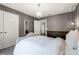 Elegant bedroom with a chandelier and a white bed set against gray walls at 9518 Lynwood St, Clermont, FL 34711