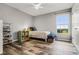 Neutral bedroom featuring hardwood floors, a single bed, and ample natural light from a large window at 9518 Lynwood St, Clermont, FL 34711