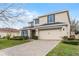 Charming home with a two-car garage, neutral colored exterior, stone accents, and a brick paver driveway at 9518 Lynwood St, Clermont, FL 34711