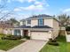 Charming home with a two-car garage, neutral colored exterior, stone accents, and a brick paver driveway at 9518 Lynwood St, Clermont, FL 34711