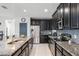 Contemporary kitchen featuring stainless steel appliances, dark cabinetry, and granite countertops at 9518 Lynwood St, Clermont, FL 34711
