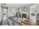 Open living room with wood flooring, a wall-mounted TV, modern chairs, and doorways to other rooms at 9518 Lynwood St, Clermont, FL 34711