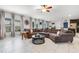 Spacious living room with tile floors, a ceiling fan, large windows, and a comfortable, oversized sectional sofa at 9518 Lynwood St, Clermont, FL 34711