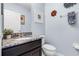 Stylish powder room with granite countertop vanity, decorative accents, and contemporary fixtures at 9518 Lynwood St, Clermont, FL 34711