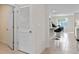 Hallway leading to a kitchen featuring tile flooring, an open doorway, and access to the rest of the house at 1072 Clay Blvd, Tavares, FL 32778