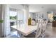 Open-concept dining area with a white table, seating for six, and natural light from the sliding glass doors at 1074 Clay Blvd, Tavares, FL 32778