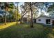 View of the backyard with a screened-in pool, some mature trees and lush green grass at 109 Crestwood Dr, Longwood, FL 32779