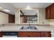 Bright kitchen with stainless steel sink and pass-through window to a screened-in pool at 109 Crestwood Dr, Longwood, FL 32779