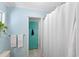 Bathroom featuring a turquoise accent door, shower, and neutral wall paint at 11595 Sw 134 Ct, Dunnellon, FL 34432