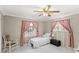 Cozy bedroom with white marble floors, plush pink drapes and natural lighting from the two windows at 11595 Sw 134 Ct, Dunnellon, FL 34432