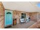 Inviting front porch with a pop of color from the front door and cozy seating area at 11595 Sw 134 Ct, Dunnellon, FL 34432