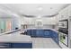 Bright eat-in kitchen featuring white cabinetry, blue lower cabinets, and an island with bar seating at 11595 Sw 134 Ct, Dunnellon, FL 34432