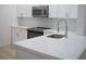 Well-lit kitchen featuring white cabinets, quartz countertops, and stainless steel appliances at 122 Vista Verdi Cir # 216, Lake Mary, FL 32746