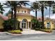 Exterior of clubhouse featuring a red tile roof, arched entrance, and lush tropical landscaping at 12204 Wild Iris Way # 109, Orlando, FL 32837