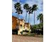 Entrance to Villanova community with lush tropical landscaping and orange residential building at 12204 Wild Iris Way # 109, Orlando, FL 32837