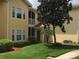 Exterior view of a two-story condo building featuring a balcony and manicured landscaping at 12204 Wild Iris Way # 109, Orlando, FL 32837