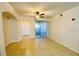 Open living room featuring neutral tile flooring, ceiling fan, and sliding door to balcony at 12204 Wild Iris Way # 109, Orlando, FL 32837