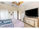 Cozy bedroom featuring a ceiling fan and a large TV on a wooden cabinet at 13221 Fountainbleau Dr, Clermont, FL 34711