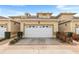 Townhouse featuring a clean, well-maintained white garage door and nice landscaping at 13221 Fountainbleau Dr, Clermont, FL 34711